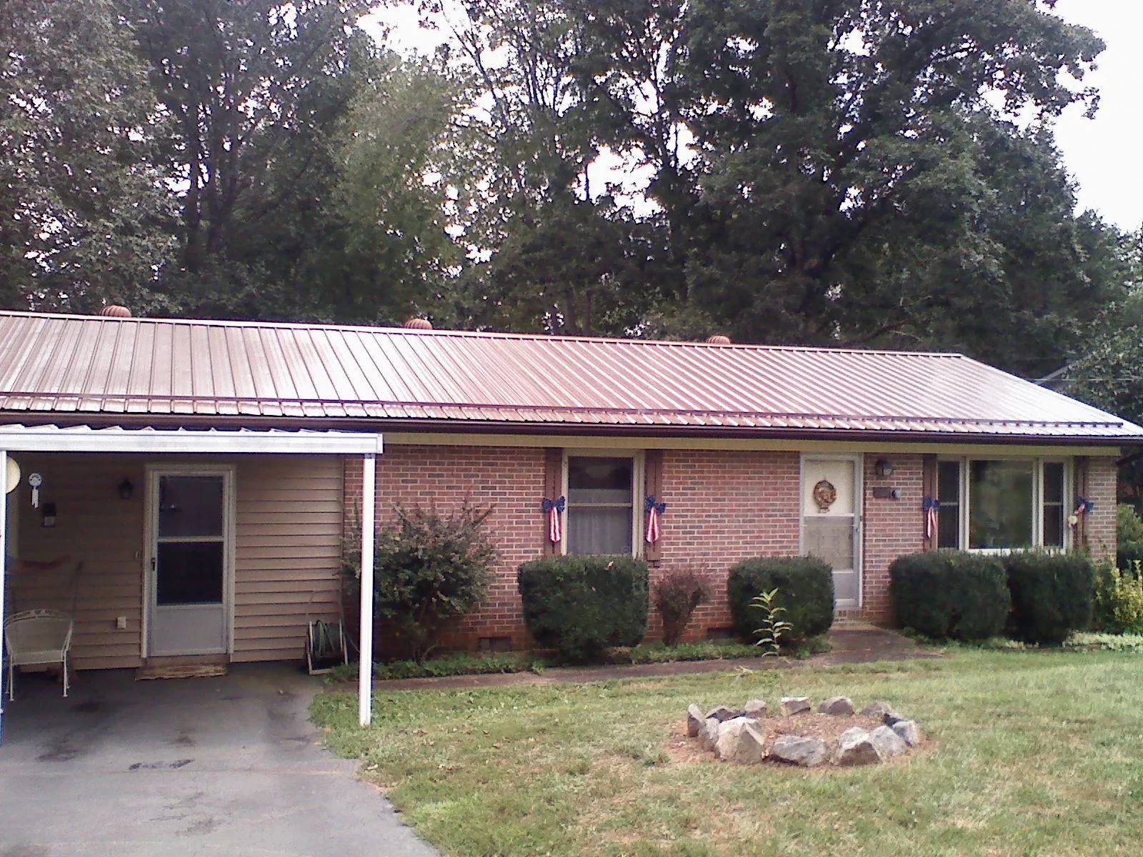 Bronze metal roof and carport on a brick ranch home — Roof Repair work by our crew in Molina